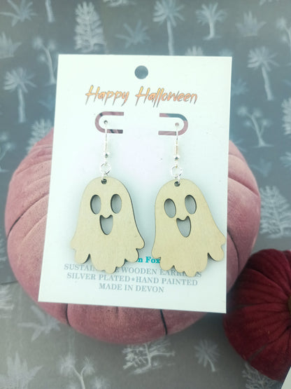 Ghost-shaped earrings on a 'Happy Halloween' card 