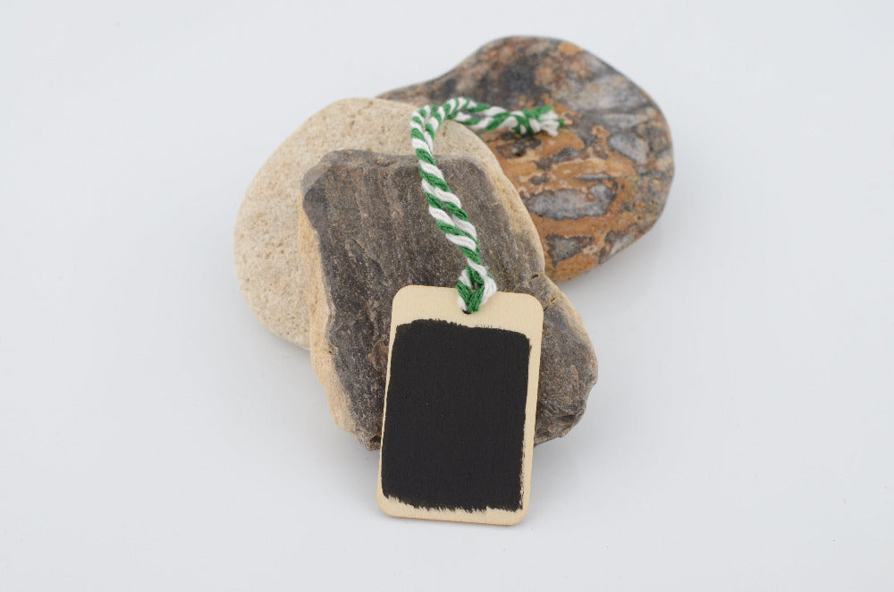Decorative stone with a small chalkboard tag on a white background